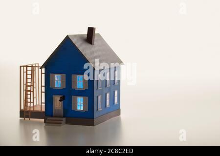 Illuminated model house with ladder and extension Stock Photo
