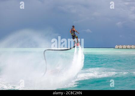 Flying Reeds Sports Professional pro fly board rider in tropical sea, water sports concept ...
