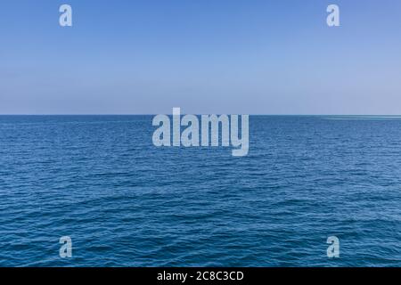 Seascape with sea horizon and almost clear deep blue sky background Stock Photo