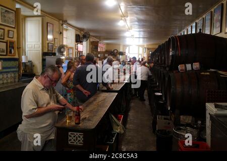 Malaga, Andalusia / Spain / September 13 2016 : Customers enjoy beer and  wine at a traditional bar in the centre of the city. Wooden barrels line the Stock Photo