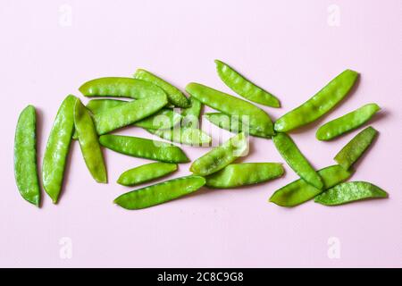 Frozen vegetables such as pea pods on a pink background. Top view. Horizontal orientation Stock Photo