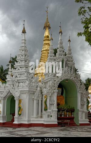 Stupas inside the Shwedagon Pagoda in Yangon, Myanmar, often with turban and umbrella at the top of their spire. Stock Photo
