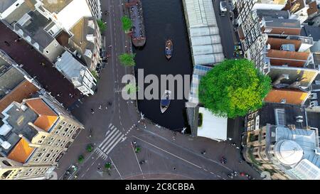 Amsterdam, Netherlands aerial top view. Famous dutch canal and panorama of Amsterdam city during golden hour, sunset. Stock Photo