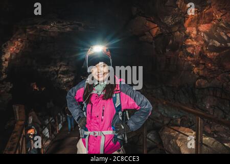 Woman traveler explore lava tunnel in Iceland. Stock Photo