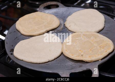 Nutritious handmade corn tortilla cooked on a metal griddle on a gas stove in a Guatemalan home. Stock Photo