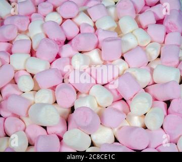 Closeup of pink and white vanilla-flavoured, mini marshmallows – sweet, soft and chewy, used for home baking and also to float in hot drinks. Stock Photo