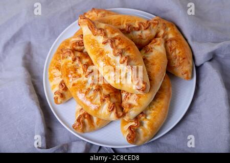 Pies (pirozhki) with cabbage. Homemade baking. Traditional Russian and Ukrainian cuisine. Close-up. Stock Photo