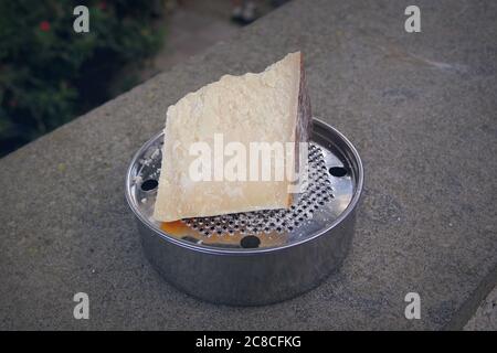 A chunk of parmesan cheese on a typical Italian grater, called ratta Stock Photo