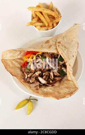 Shawarma shavings in a Lafa -  flat Iraqi pita with pickles and french fries. A popular fast food in Israel and the Middle East Stock Photo