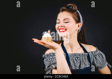 Young woman on diet with closed eyes dreaming how she would enjoy delicious cupcake that she holding in hand ,smelling its flavor Stock Photo