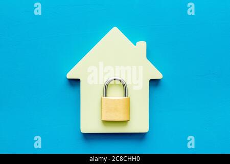 Security concept - lock and house figure - on blue desk top-down Stock Photo