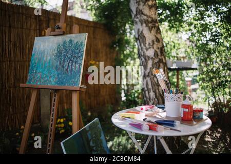 Artist's workshop in backyard with tree and plants Stock Photo