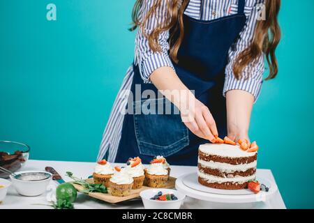 Pastry Chef woman hands decorating chocolate cream layers pie with berries Stock Photo