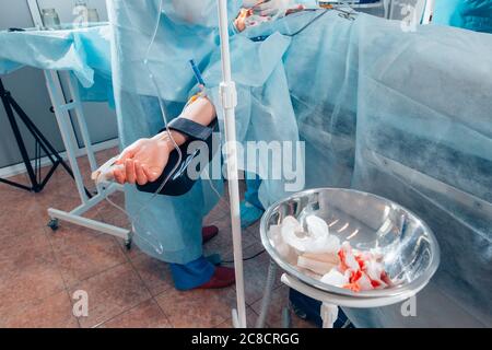 Patient lying on the bed restraint the arm with cotton on operating table Stock Photo