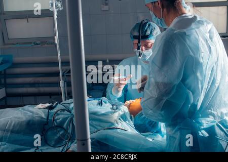 Medical team performing operation on nose. Group of surgeon at work in operating theatre Stock Photo