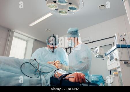 patient lies on the operating surgical table during rhinoplastic operation surgery with anesthesia Stock Photo