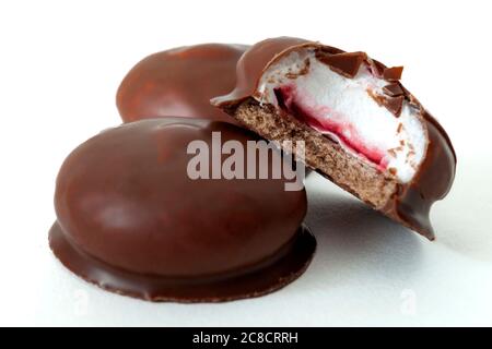 Sweet confectionery and marshmallow sweet delights concept with marshmallows coated in milk chocolate isolated on white background with a clipping pat Stock Photo