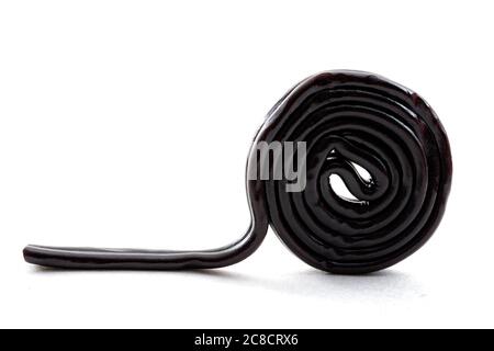 Sugar confectionery sweets and sweet candy concept with one black licorice or liquorice wheel or spiral isolated on white background Stock Photo