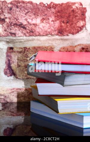 Stack of reading books on a glass table Stock Photo