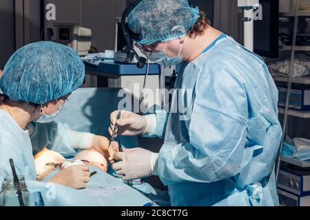 Stitching the patient's skin, the self-extracting threads, after surgery. Stock Photo