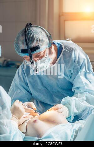 Stitching the patient's skin, the self-extracting threads, after surgery. Stock Photo