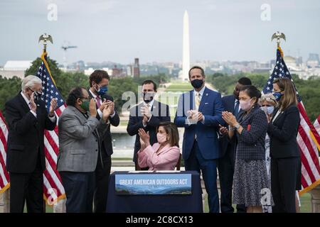 Washington, United States. 23rd July, 2020. Speaker of the House Nancy Pelosi, D-Calif., signs the Great American Outdoors Act on the West Front of the U.S. Capitol in Washington, DC, U.S., on Thursday, July 23, 2020. The act will fund maintenance projects for national parks and forests. Photo by Sarah Silbiger/UPI Credit: UPI/Alamy Live News Stock Photo