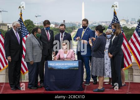 Washington, United States. 23rd July, 2020. Speaker of the House Nancy Pelosi, D-Calif., signs the Great American Outdoors Act on the West Front of the U.S. Capitol in Washington, DC, U.S., on Thursday, July 23, 2020. The act will fund maintenance projects for national parks and forests. Photo by Sarah Silbiger/UPI Credit: UPI/Alamy Live News Stock Photo