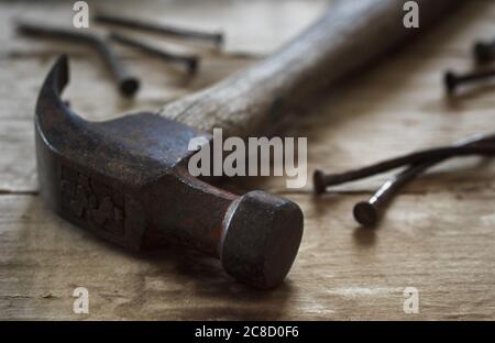 Hammer and nails on wood in natural light. Stock Photo