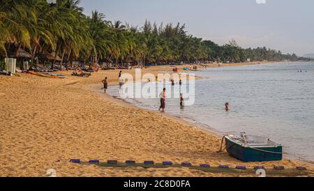 Phu Quoc, Vietnam - April 11th 2014: Tourists bathing in the sea in the evening on Ba Keo Beach, Phu Quoc, Vietnam Stock Photo