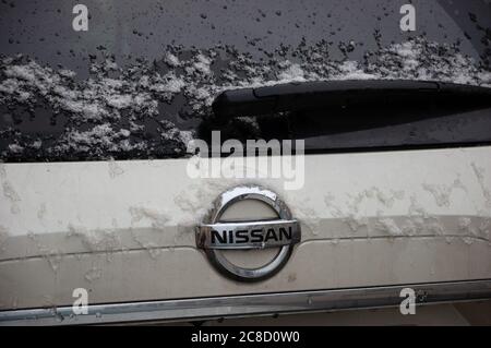 PARIS, FRANCE - FEBRUARY 5, 2018: Nissan automobile under snow in rare snowy day in winter in Paris. Closeup. Since 1999, Nissan has been part of the Stock Photo