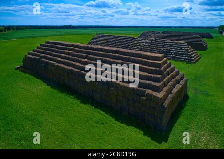 Aerial view of big pyramids made out of rectangular haystacks. Stock Photo