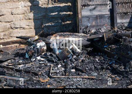 Charred remains of beach huts destroyed in fire at West Cliff beach, Bournemouth, Dorset UK in July, fire started in beach hut and spread to cliffside Stock Photo