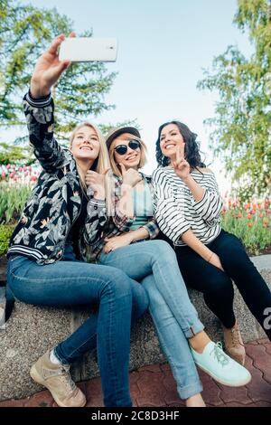 Happy female friends taking selfie on street Stock Photo