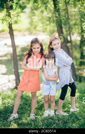 three kid sister friends girls group playing together in park Stock Photo