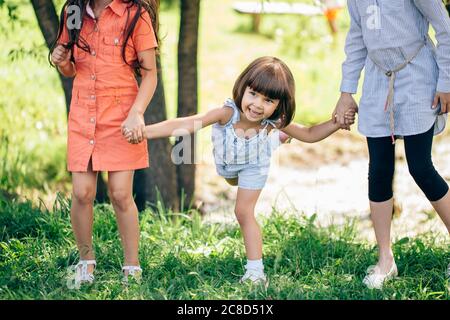 three kid sister friends girls group playing together in park Stock Photo