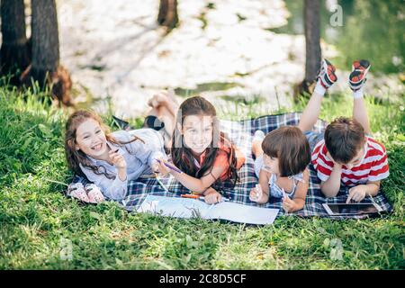 Happy pretty kids girl having fun during painting in park Stock Photo