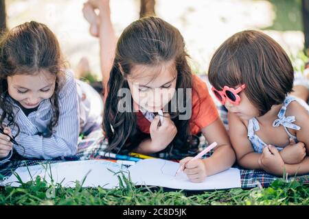 Happy pretty kids girl having fun during painting in park Stock Photo