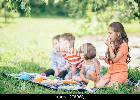 Three happy smiling child playing in park Stock Photo