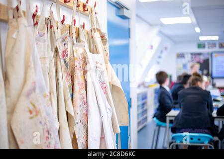 Aprons Handing Up in an Art Lesson at School Stock Photo