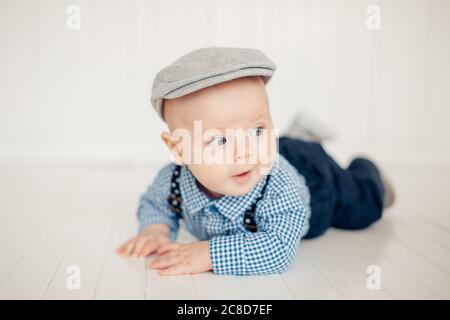 Smiling baby girl lying on a bed on blue sheets Stock Photo