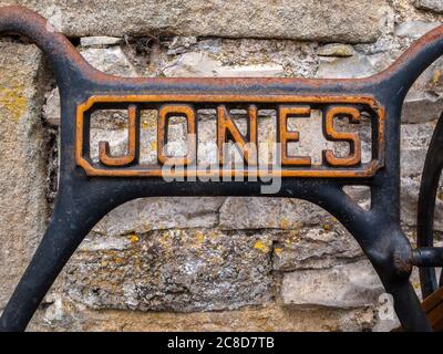 Old Jones Sewing Machine Logo with stone wall background, close-up Stock Photo
