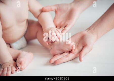 Father holds his little baby feet close up