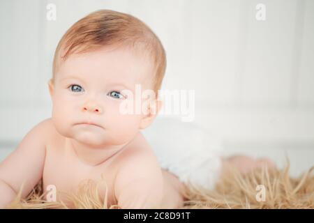 baby lying on colorful towel on bed Stock Photo