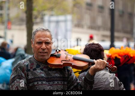 Amsterdam ,Netherlands 05/15/2010:   Portrait of a street violinist who is seen as placing the violin on his shoulder. This musician is a middle aged Stock Photo