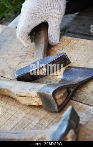 hands with white gloves using hammer and axe Stock Photo