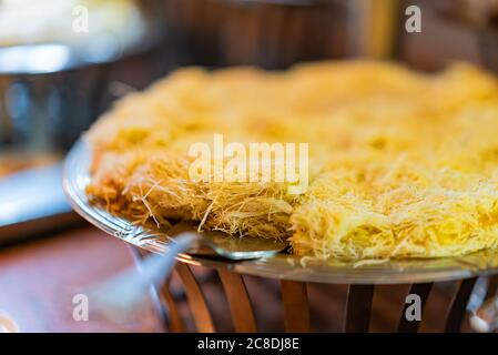 Traditional arabian Kanafe cake with Kadaif hair noodels with soft focus. Eastern cookies beautifully served on metal plate. Traditional desert in Egy Stock Photo