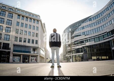 Businessman standing in the city at sunset Stock Photo