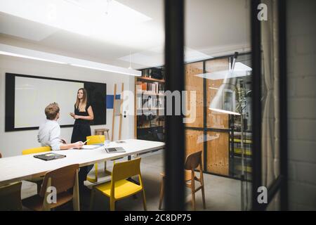 Businessman and woman preparing presentation in conference room Stock Photo