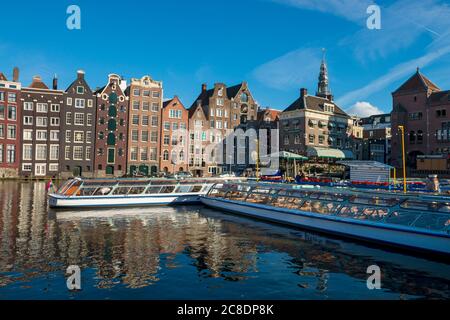 The Netherlands, North Holland Province, Amsterdam, Damrak, Tourboats and port buildings Stock Photo