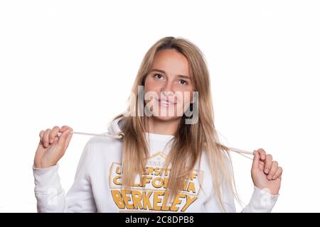 Blonde beautiful girl with long hair in a sweatshirt on a white background smiles and looks into the camera. Horizontal shot isolate, portrait of a 30 Stock Photo